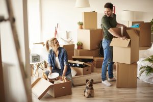 A man and woman unpacking boxes in their new home.