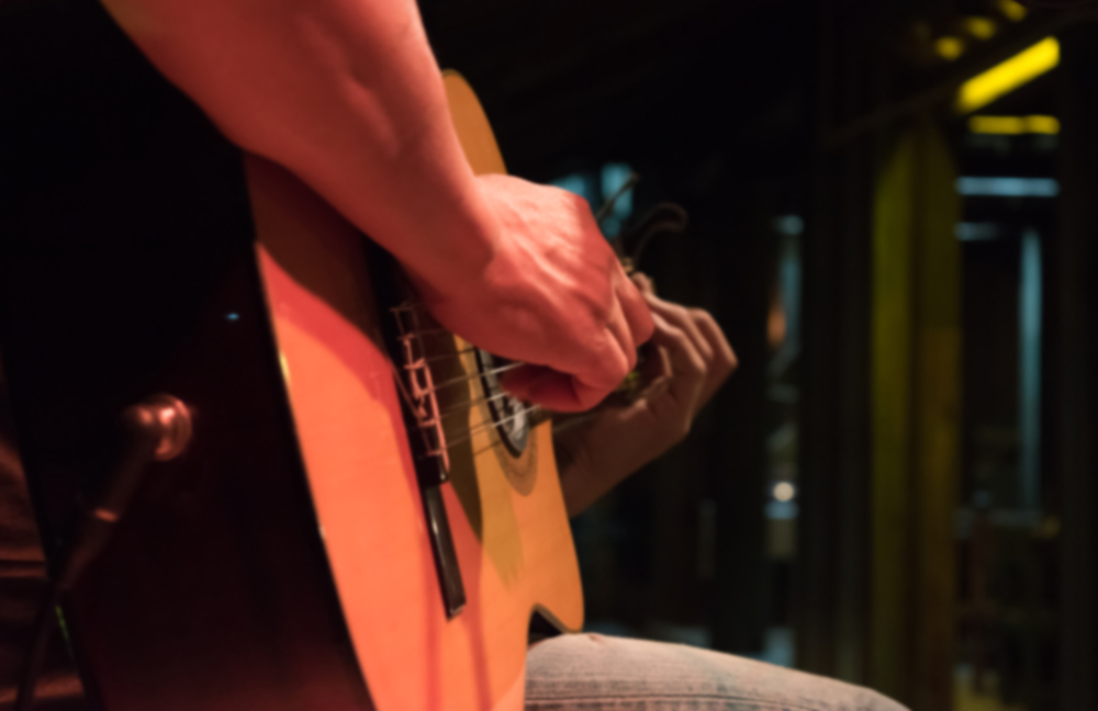 Man playing a guitar at a music festival.