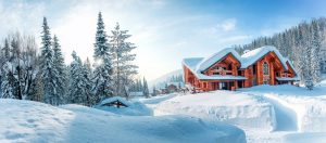 A cabin in the woods surrounded by deep snow.