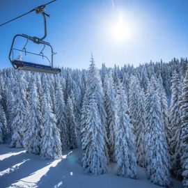 Empty ski lift against snowy mountain landscape