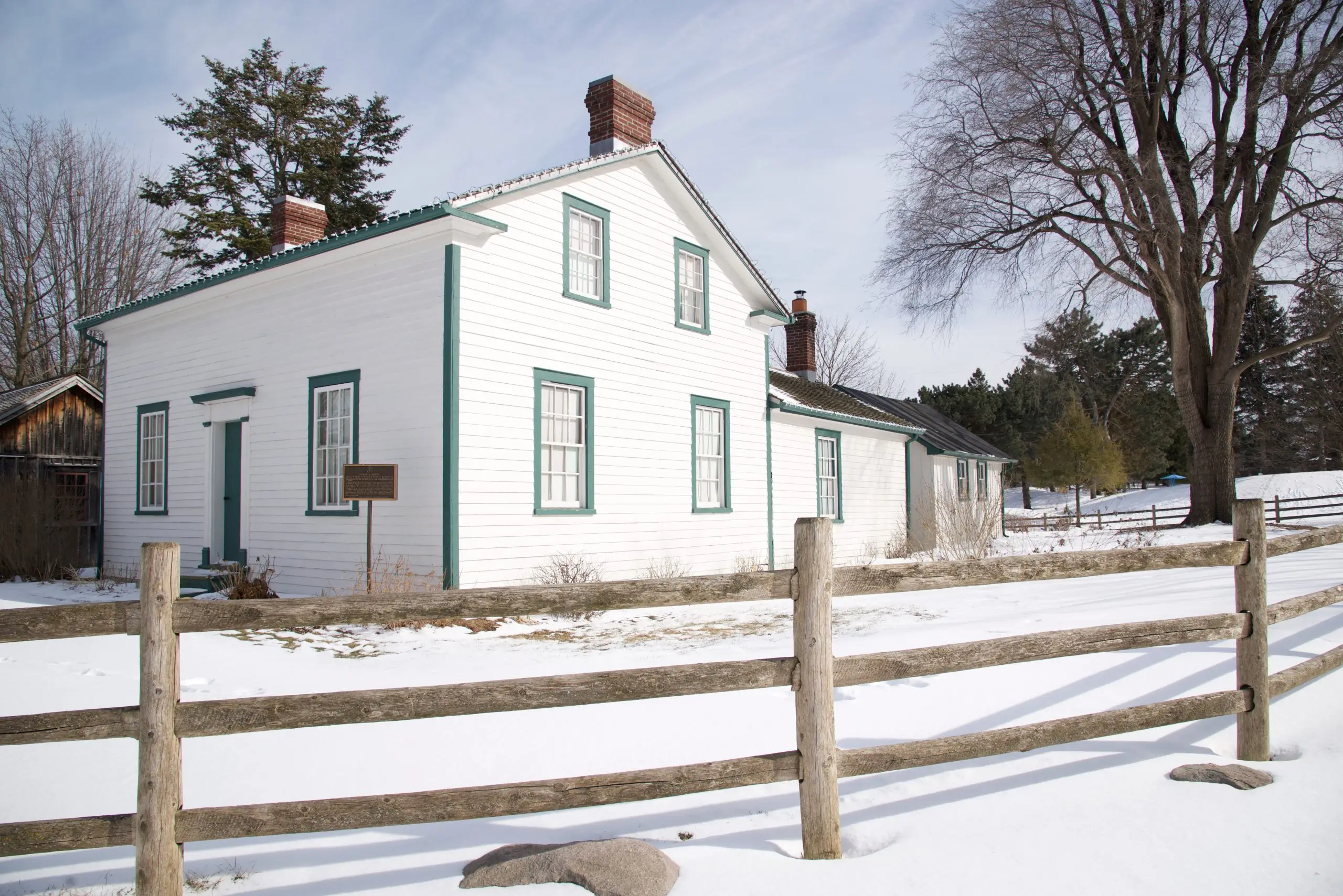 Victorian-style house exterior with wooden post and rail fence i