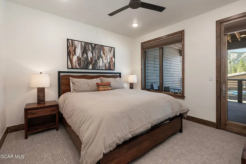 Bedroom with a large bed and deck access in a luxury Winter Park CO home